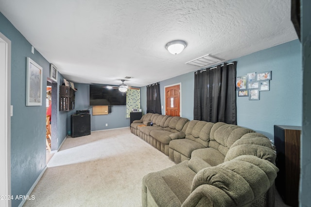 living room with ceiling fan, a textured ceiling, and carpet