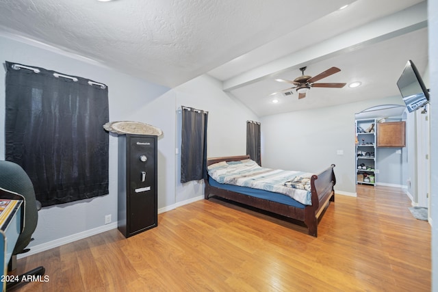 bedroom with ceiling fan, lofted ceiling with beams, light hardwood / wood-style flooring, and a textured ceiling