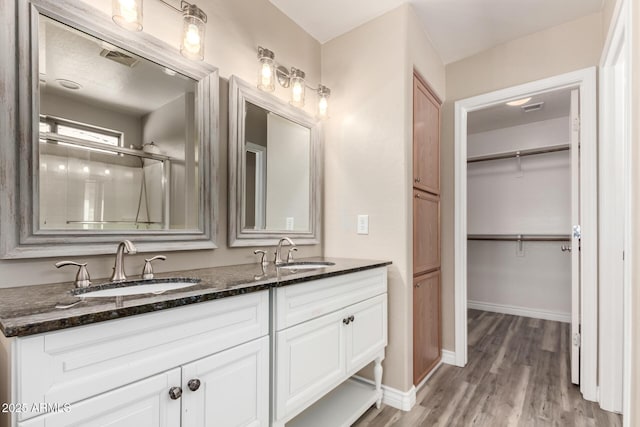1968 E Emily Ln, Gilbert, AZ 85295 - bathroom with baseboards, a sink, wood finished floors, and double vanity