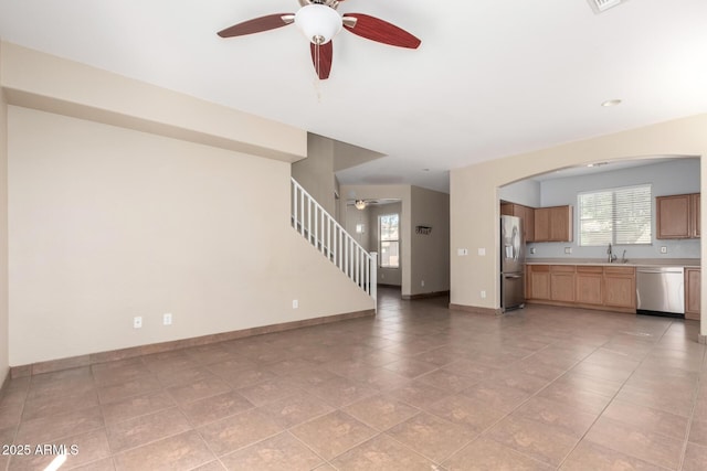 1968 E Emily Ln, Gilbert, AZ 85295 - unfurnished living room with a ceiling fan, a sink, light tile patterned floors, baseboards, and stairs