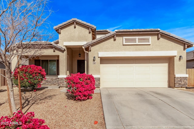 view of front of home with an attached garage, stone siding, concrete driveway, and stucco siding