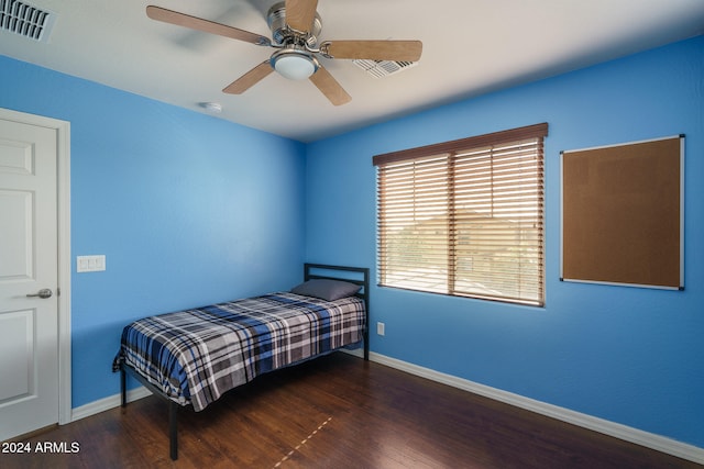 bedroom with dark hardwood / wood-style flooring and ceiling fan