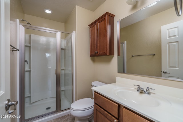 bathroom featuring an enclosed shower, vanity, and toilet