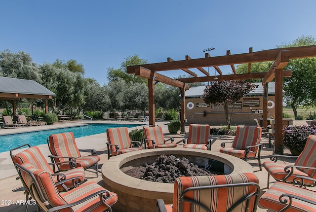 view of swimming pool featuring a pergola and a fire pit