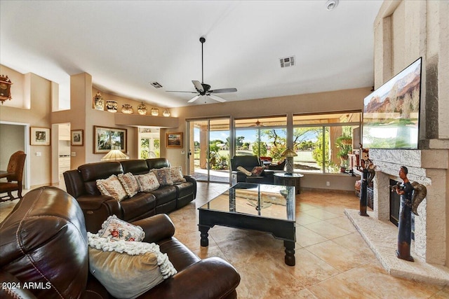 living room with a fireplace, light tile patterned flooring, ceiling fan, and high vaulted ceiling