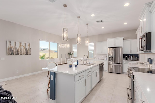 17896 W Amberwood Dr, Goodyear, AZ 85338 - kitchen featuring an island with sink, visible vents, appliances with stainless steel finishes, light countertops, and a sink