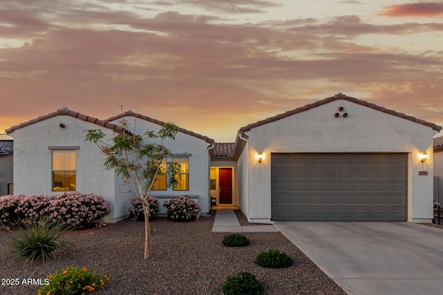 17896 W Amberwood Dr, Goodyear, AZ 85338 - mediterranean / spanish house featuring a garage, stucco siding, a tiled roof, and concrete driveway