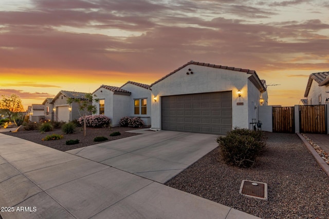 17896 W Amberwood Dr, Goodyear, AZ 85338 - mediterranean / spanish-style house with concrete driveway, stucco siding, an attached garage, a tile roof, and a gate