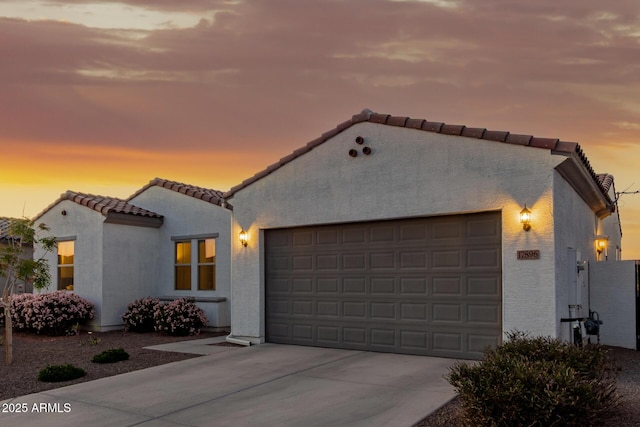 17896 W Amberwood Dr, Goodyear, AZ 85338 - mediterranean / spanish-style home featuring a tile roof, an attached garage, stucco siding, and concrete driveway