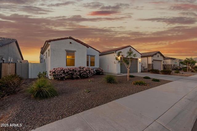 17896 W Amberwood Dr, Goodyear, AZ 85338 - mediterranean / spanish house featuring a tiled roof, stucco siding, fence, an attached garage, and concrete driveway