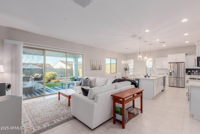17896 W Amberwood Dr, Goodyear, AZ 85338 - living room featuring recessed lighting, light tile patterned floors, visible vents, and an inviting chandelier