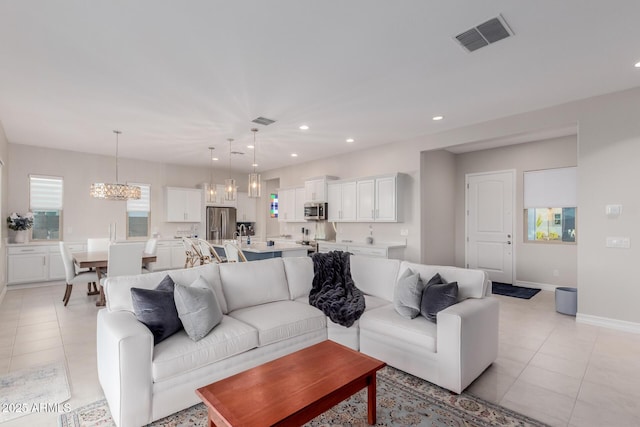 17896 W Amberwood Dr, Goodyear, AZ 85338 - living room with an inviting chandelier, recessed lighting, visible vents, and light tile patterned floors