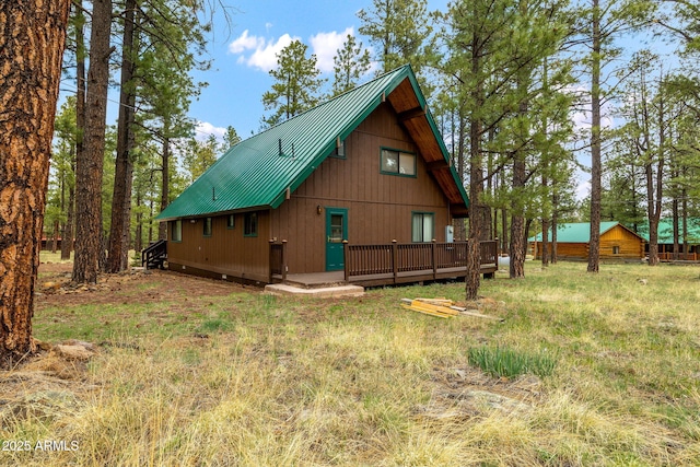 back of property featuring metal roof and a deck
