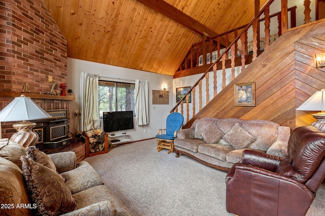 carpeted living room with high vaulted ceiling, beamed ceiling, a fireplace, stairway, and wooden ceiling