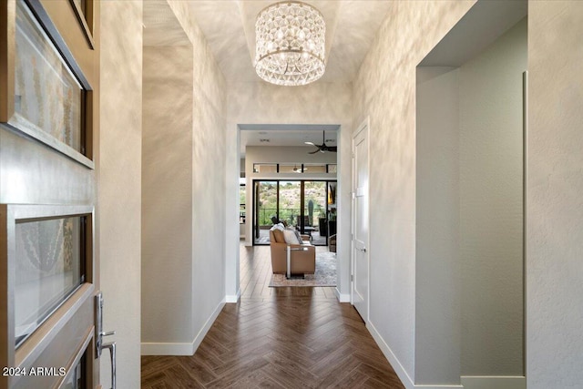 hall with an inviting chandelier and dark parquet flooring