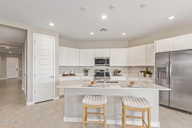 4371 E Enmark Dr, San Tan Valley, AZ 85143 - kitchen with appliances with stainless steel finishes, recessed lighting, light countertops, a kitchen breakfast bar, and a kitchen island with sink