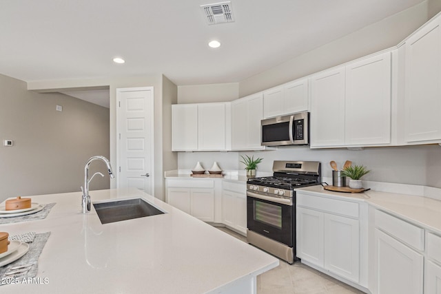 4371 E Enmark Dr, San Tan Valley, AZ 85143 - kitchen with stainless steel appliances, light countertops, white cabinetry, recessed lighting, and light tile patterned floors