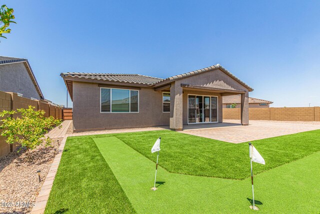 4371 E Enmark Dr, San Tan Valley, AZ 85143 - back of house with a putting area, a fenced backyard, a patio area, stucco siding, and a tiled roof