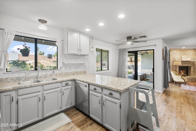 1408 N 62nd Pl, Mesa, AZ 85205 - kitchen featuring dishwasher, a sink, a peninsula, ceiling fan, and light wood-type flooring