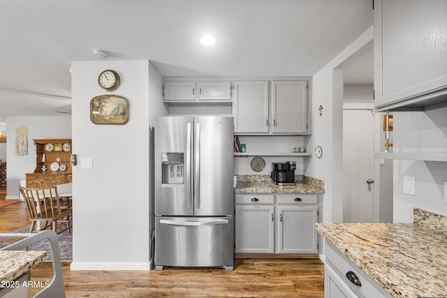 1408 N 62nd Pl, Mesa, AZ 85205 - kitchen featuring stainless steel fridge with ice dispenser, light stone counters, light wood-style flooring, and baseboards