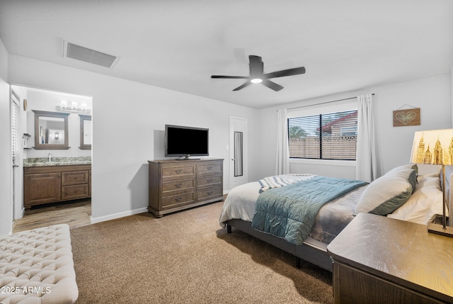 1408 N 62nd Pl, Mesa, AZ 85205 - bedroom featuring a sink, light carpet, baseboards, connected bathroom, and a ceiling fan
