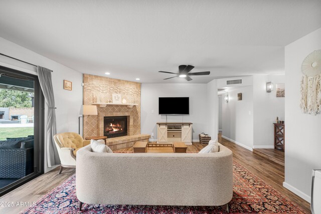 1408 N 62nd Pl, Mesa, AZ 85205 - living area featuring wood finished floors, a tiled fireplace, ceiling fan, baseboards, and recessed lighting