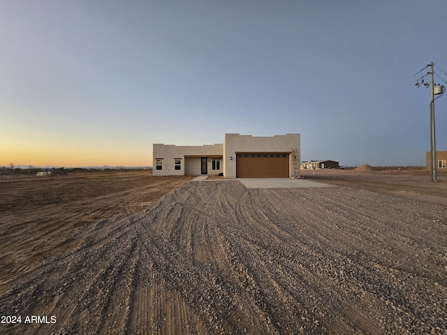 adobe home featuring a garage and a rural view