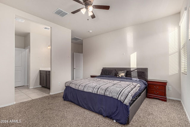 carpeted bedroom featuring ceiling fan and ensuite bath