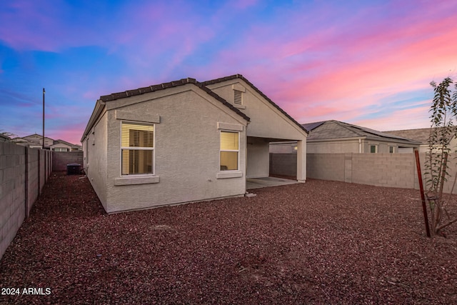 back house at dusk with a patio