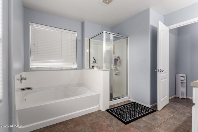 bathroom featuring a bath, stone finish floor, visible vents, and a stall shower