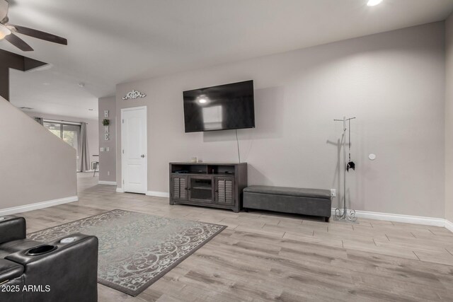 living room with baseboards, a ceiling fan, and wood finished floors