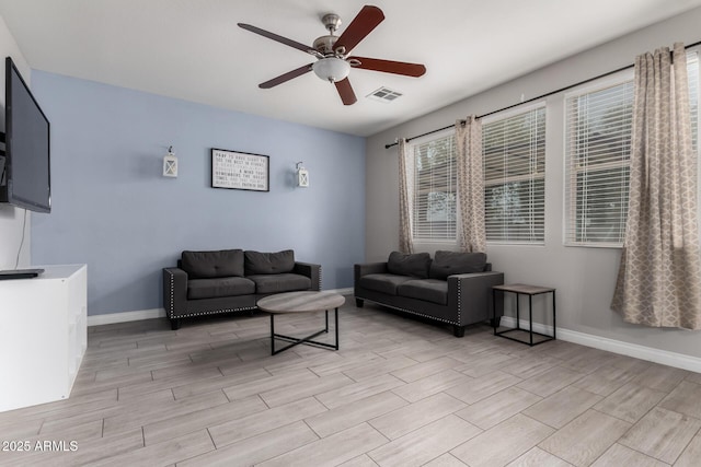 living room featuring baseboards, a ceiling fan, visible vents, and wood tiled floor