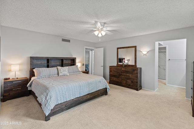 bedroom with visible vents, a ceiling fan, light carpet, baseboards, and a textured ceiling