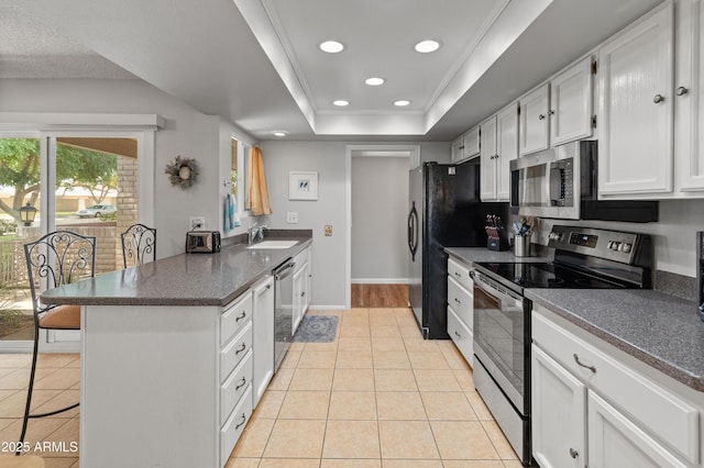 kitchen with stainless steel appliances, a peninsula, a sink, and light tile patterned floors