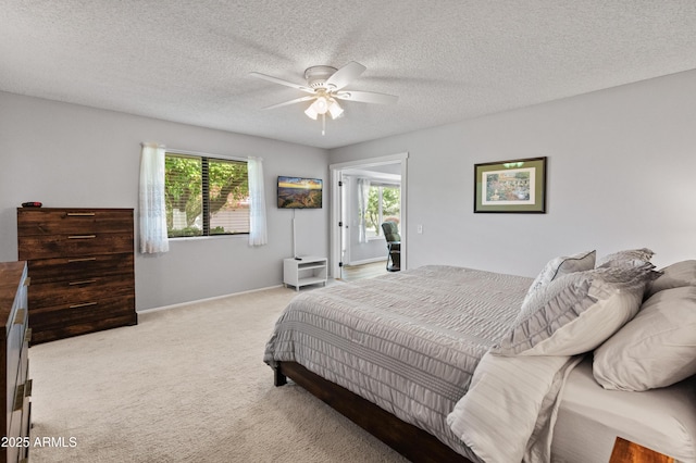 bedroom with a ceiling fan, baseboards, a textured ceiling, and light colored carpet