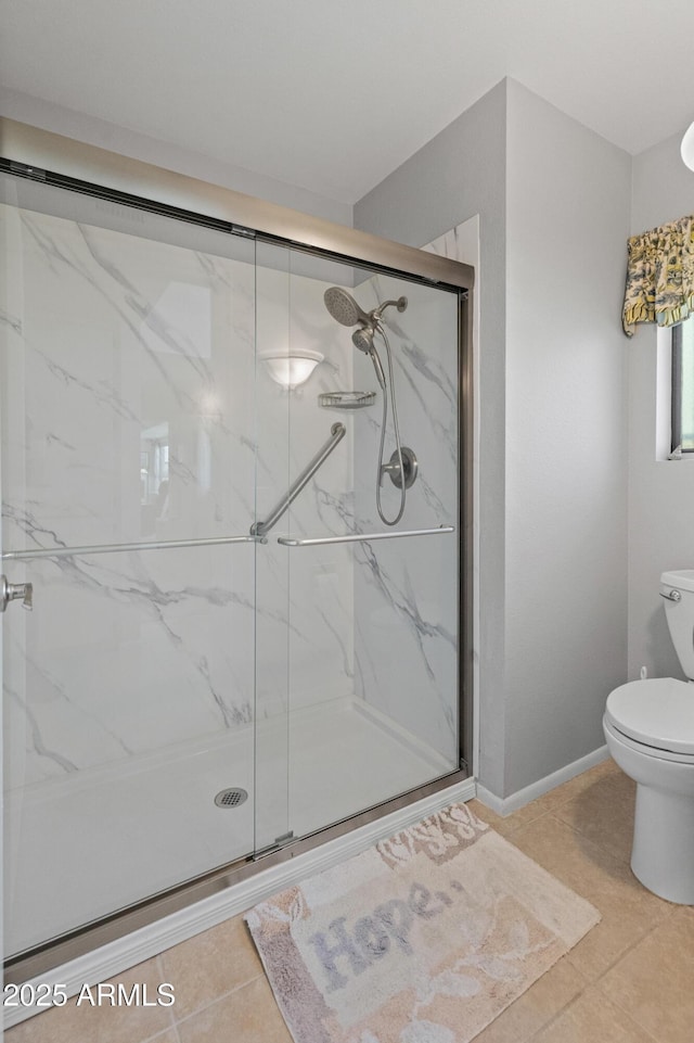 full bath featuring a marble finish shower, tile patterned flooring, and toilet