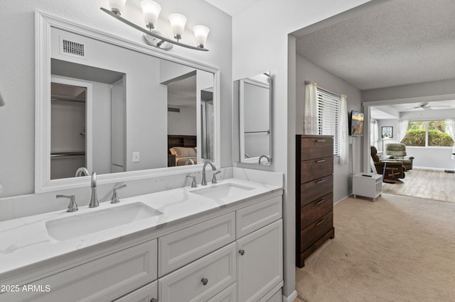 ensuite bathroom with a ceiling fan, ensuite bath, a sink, and double vanity