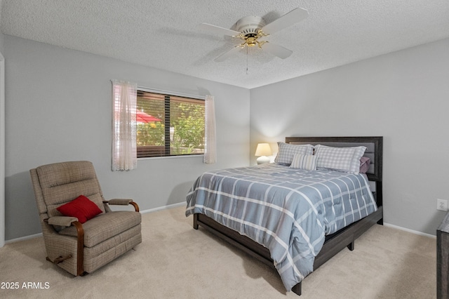 carpeted bedroom featuring baseboards, a ceiling fan, and a textured ceiling