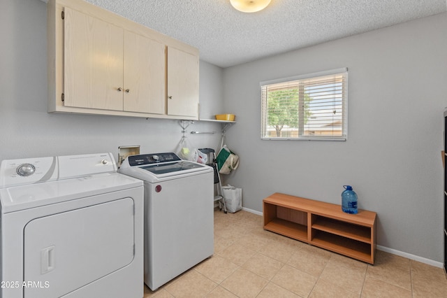 laundry area featuring light tile patterned flooring, independent washer and dryer, baseboards, cabinet space, and a textured ceiling