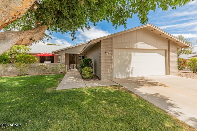 ranch-style home featuring an attached garage, a front lawn, brick siding, and concrete driveway