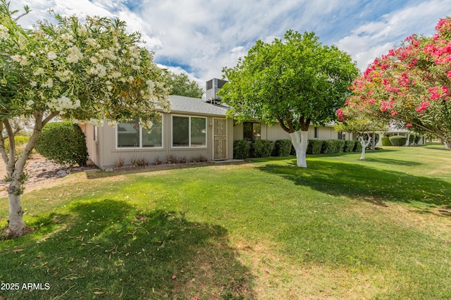 view of front of property with central AC and a front yard