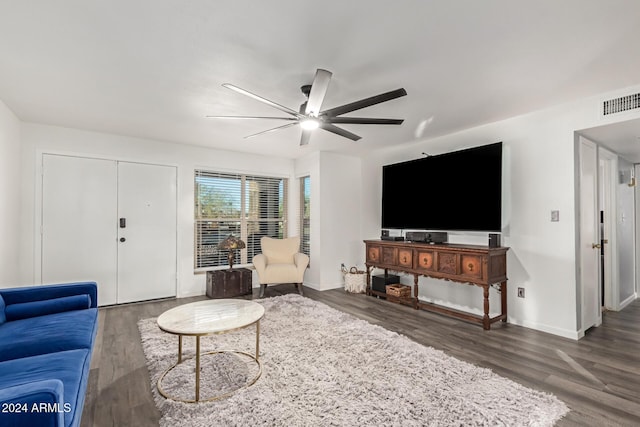 living area featuring dark wood-style floors, baseboards, visible vents, and a ceiling fan