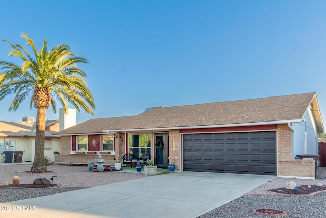 single story home with brick siding, driveway, an attached garage, and roof with shingles