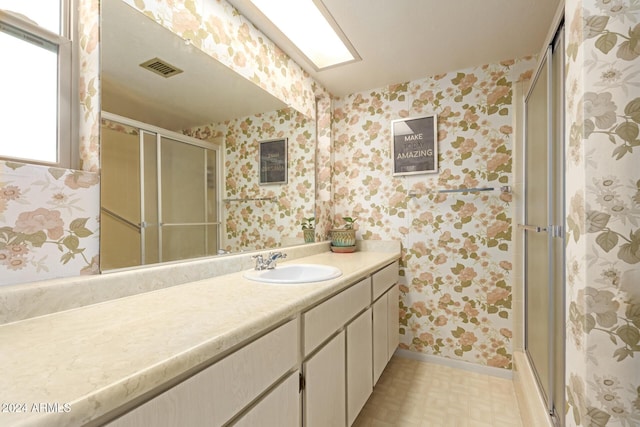 full bath featuring visible vents, vanity, a shower stall, and wallpapered walls