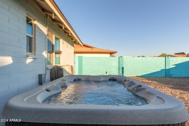 exterior space with a fenced backyard and a hot tub