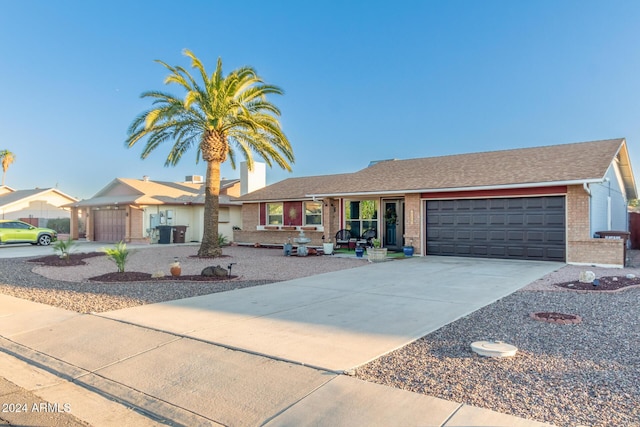 ranch-style house with a garage, concrete driveway, and brick siding