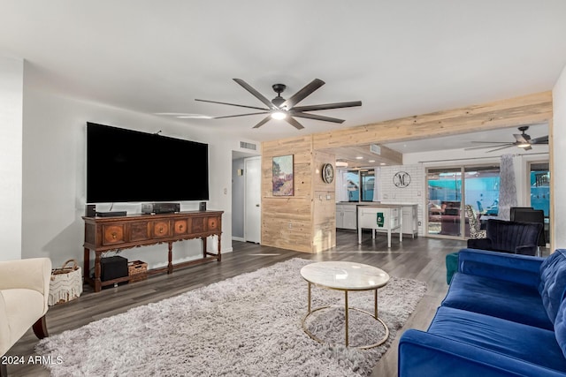 living area with a ceiling fan, beam ceiling, visible vents, and dark wood finished floors