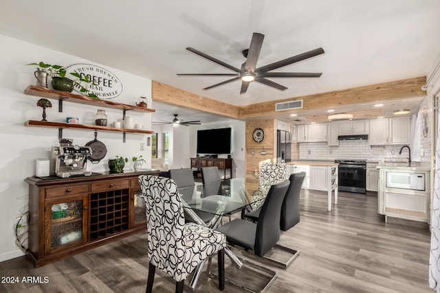 dining area featuring beam ceiling, visible vents, and wood finished floors