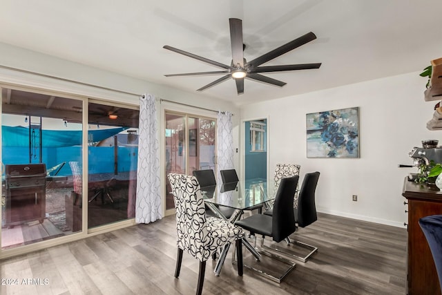 dining area with a ceiling fan, baseboards, and wood finished floors