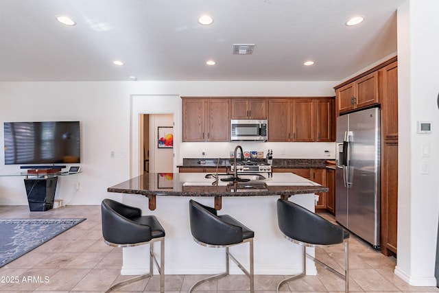 kitchen featuring a breakfast bar area, visible vents, appliances with stainless steel finishes, light tile patterned floors, and recessed lighting
